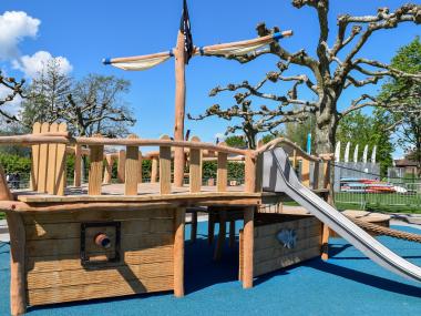 Kletterturm in Form eines Segelschiffes mit Rutsche auf Spielplatz